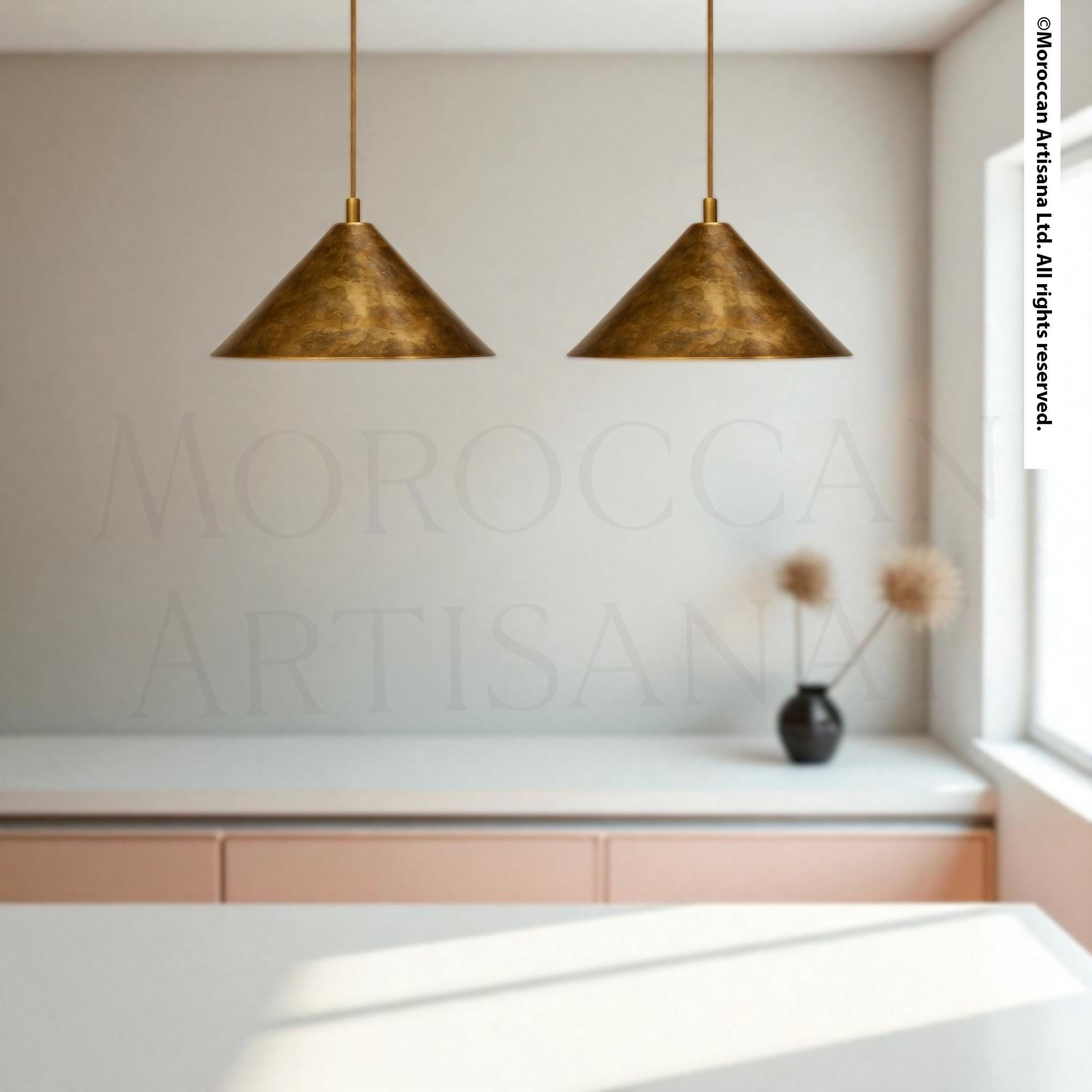 a modern kitchen with a minimalist design, featuring two pendant lights hanging above a white countertop.
