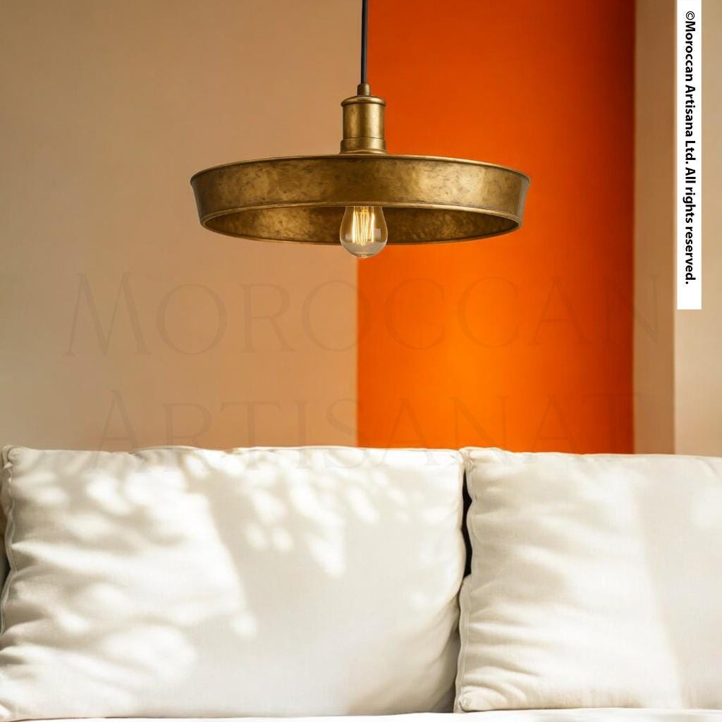 a modern living room with a white sofa and a hanging light fixture with a single bulb.