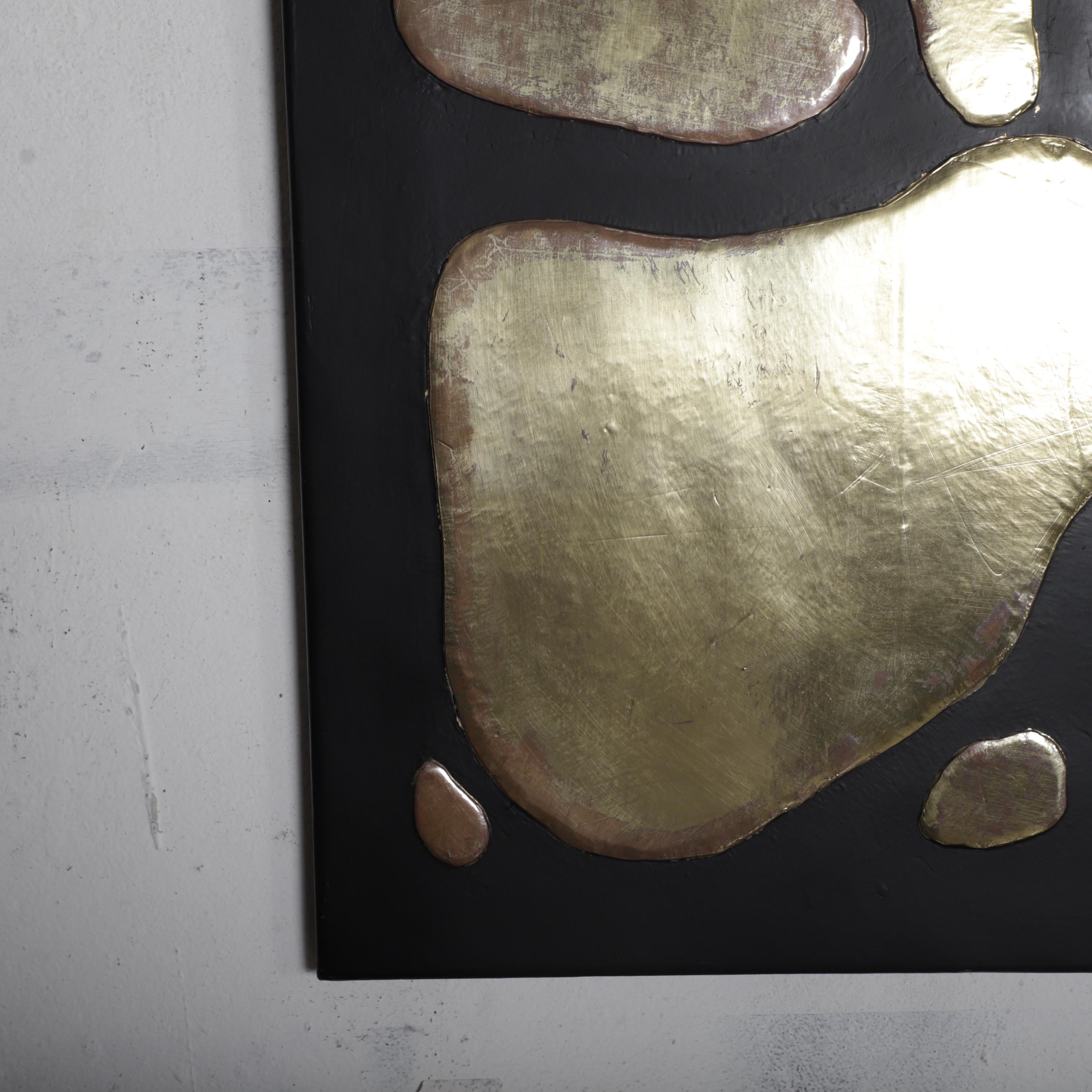 a close-up view of a black surface with a metallic, textured design composed of small, irregularly shaped pieces.