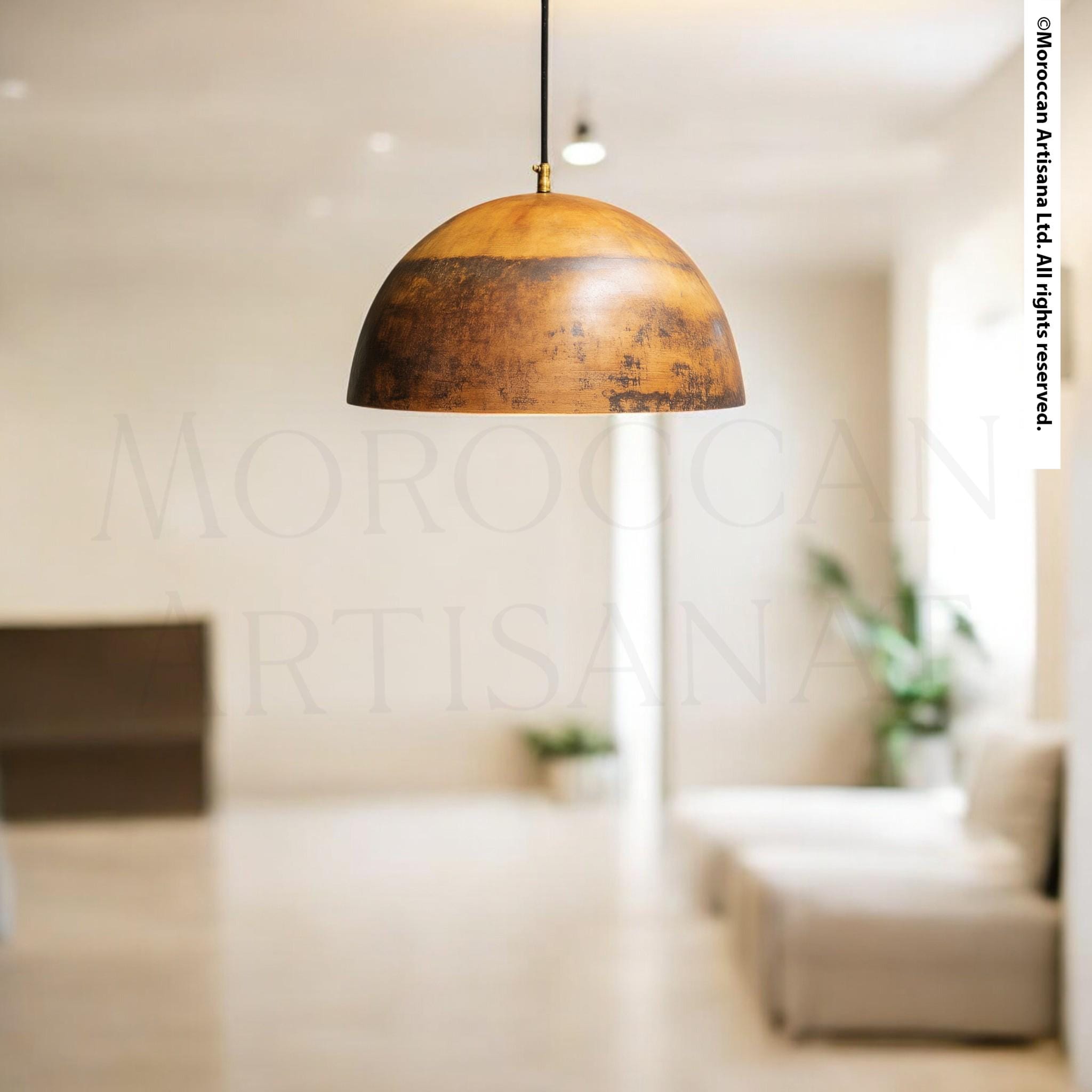 a modern interior design with a large, round pendant light hanging from the ceiling. The room has a minimalist and clean aesthetic, with white walls and a wooden floor. There is a couch and a plant in the background, adding a touch of greenery to the space.