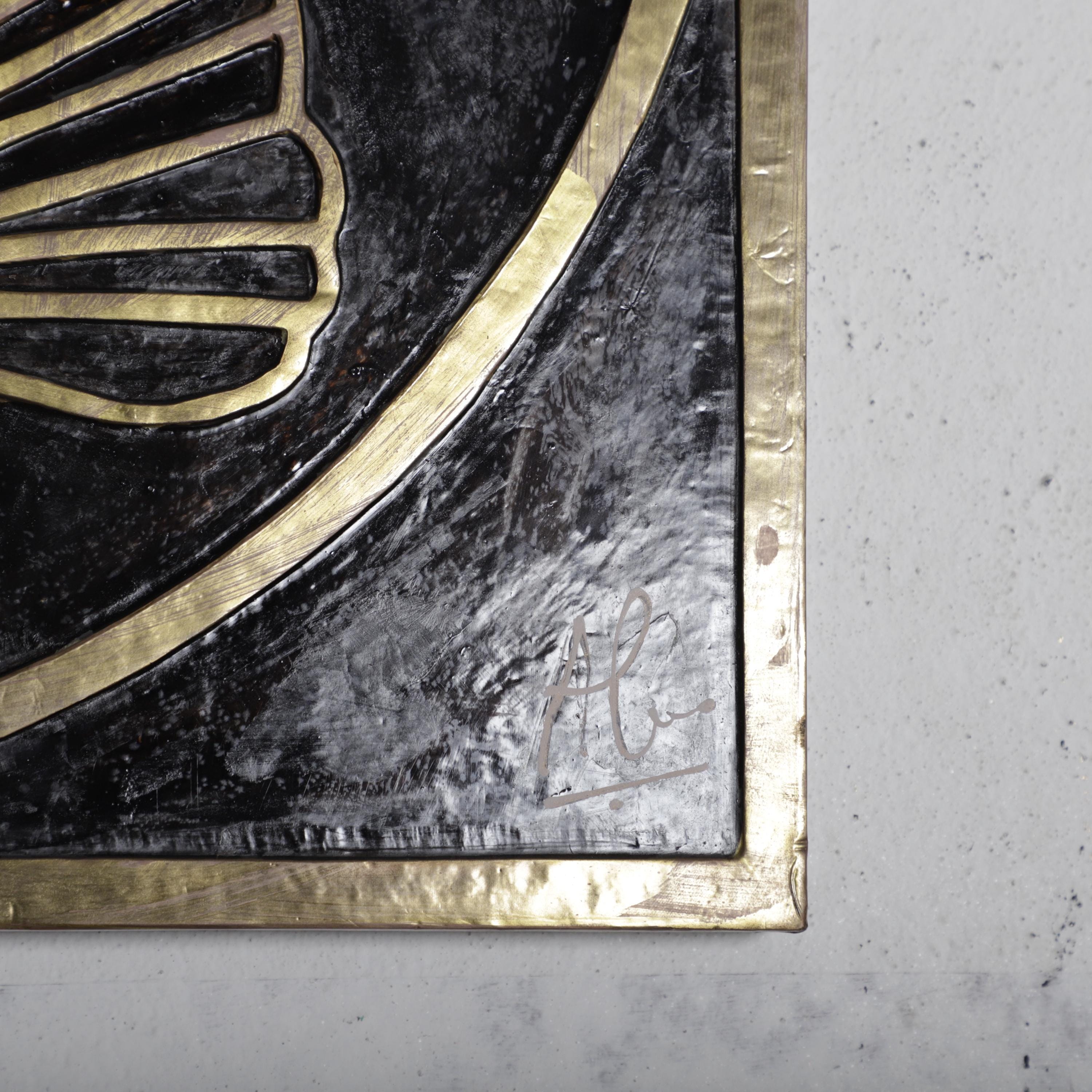 a close-up view of a black and gold decorative surface, possibly a piece of wall art or a framed photograph.