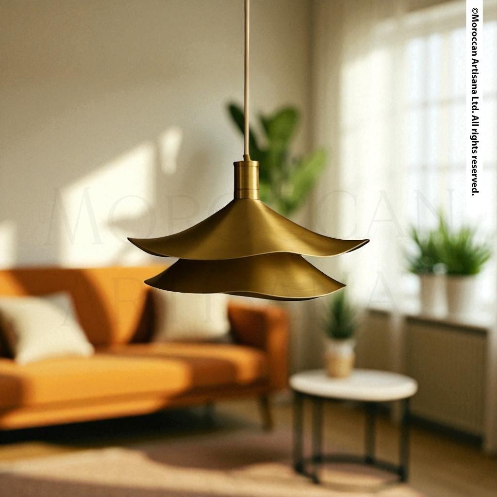 a modern living room with a gold pendant lamp hanging from the ceiling, casting a warm glow over the space. The room is furnished with a comfortable orange sofa and a round coffee table, creating a cozy and inviting atmosphere. In the background, there is a window with white curtains, allowing natural light to enter the room. A potted plant adds a touch of greenery to the space, and a white vase is visible on the coffee table.