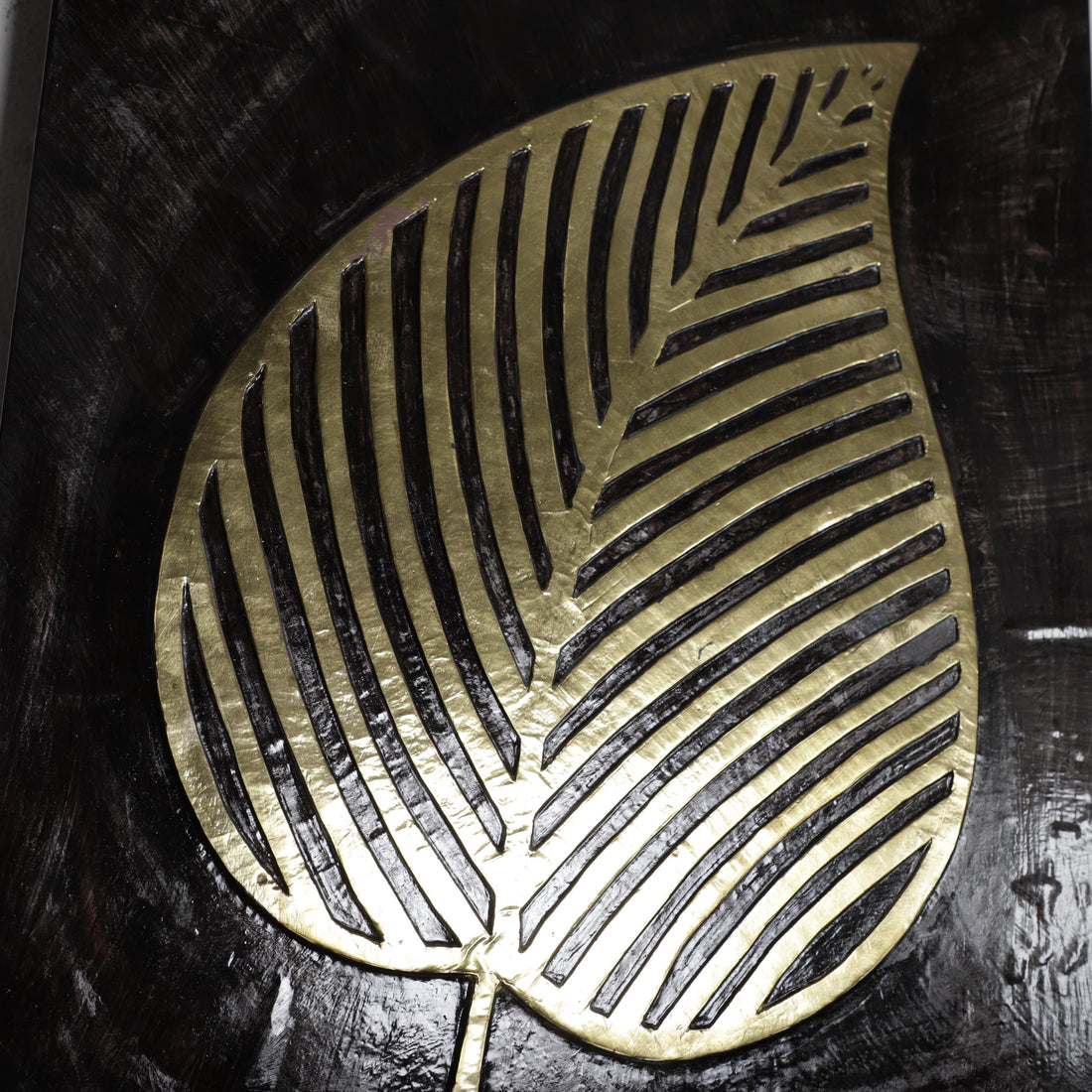 a close-up view of a leaf-shaped object with a metallic, golden-colored design.