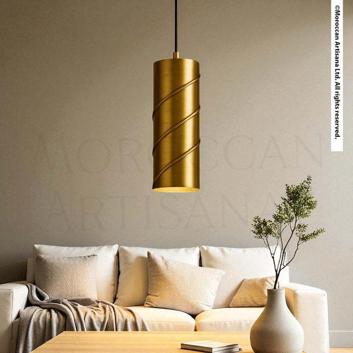 a modern living room with a gold-colored cylindrical pendant light hanging above a white sofa. The sofa is adorned with a plant in a white vase, and there is a wooden coffee table in front of the sofa. The overall color scheme of the room is neutral, with a touch of gold adding a luxurious touch to the space.