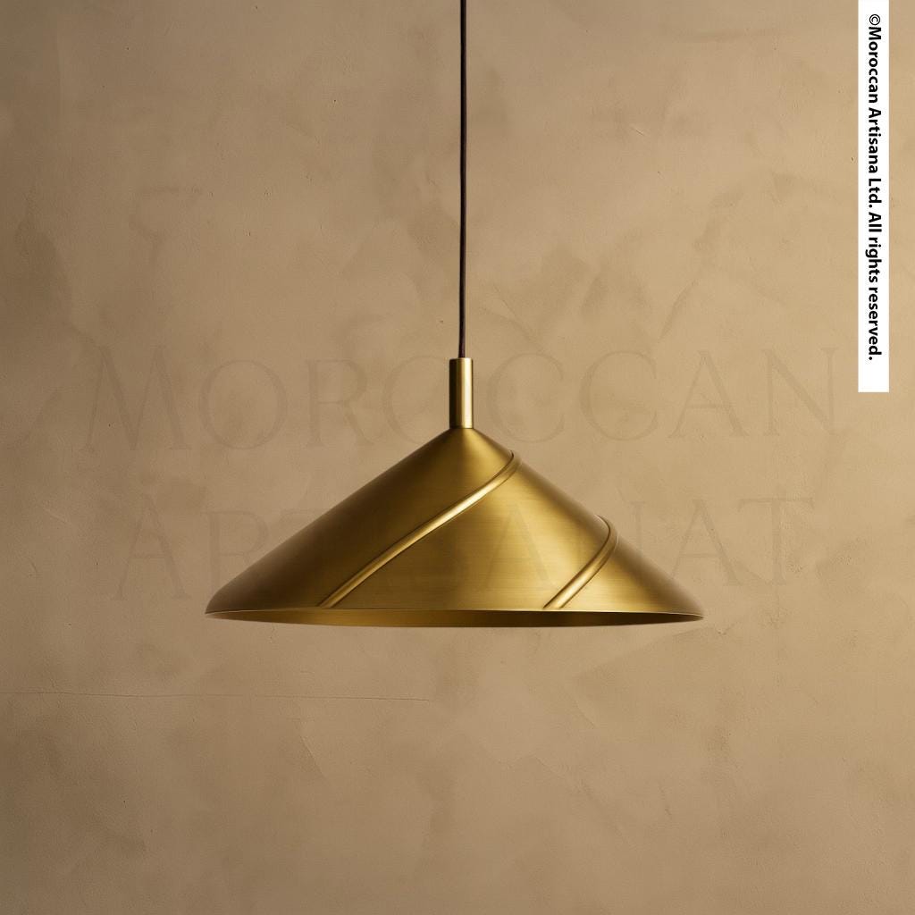 A gold-colored pendant light hangs from the ceiling against a beige wall.