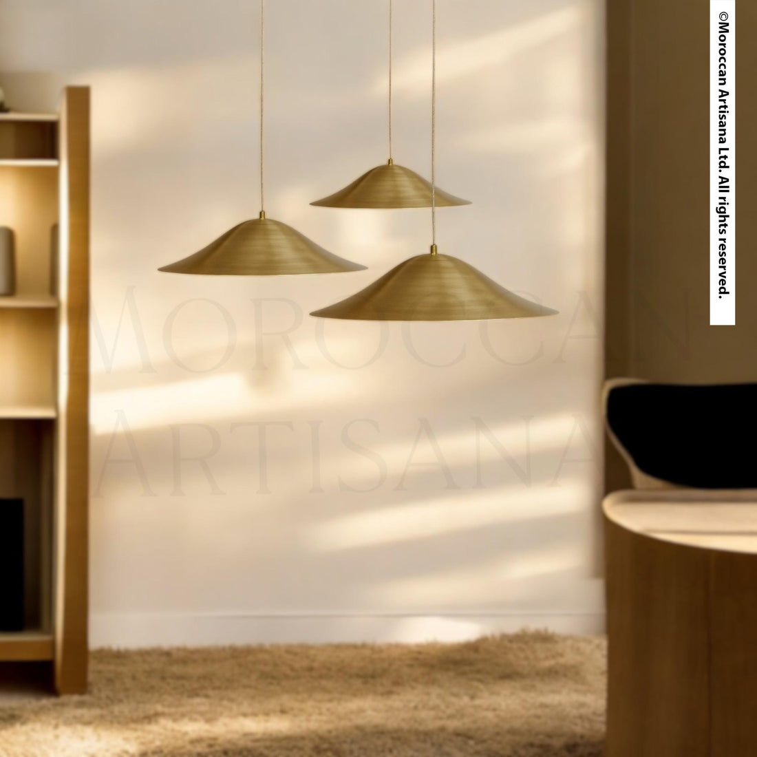 a modern living room with a minimalist design. Three pendant lights hang from the ceiling, casting a warm glow over the space. The room is furnished with a wooden coffee table and a black chair, creating a cozy and inviting atmosphere. The overall color scheme is neutral, with the gold-colored pendant lights providing a striking contrast.