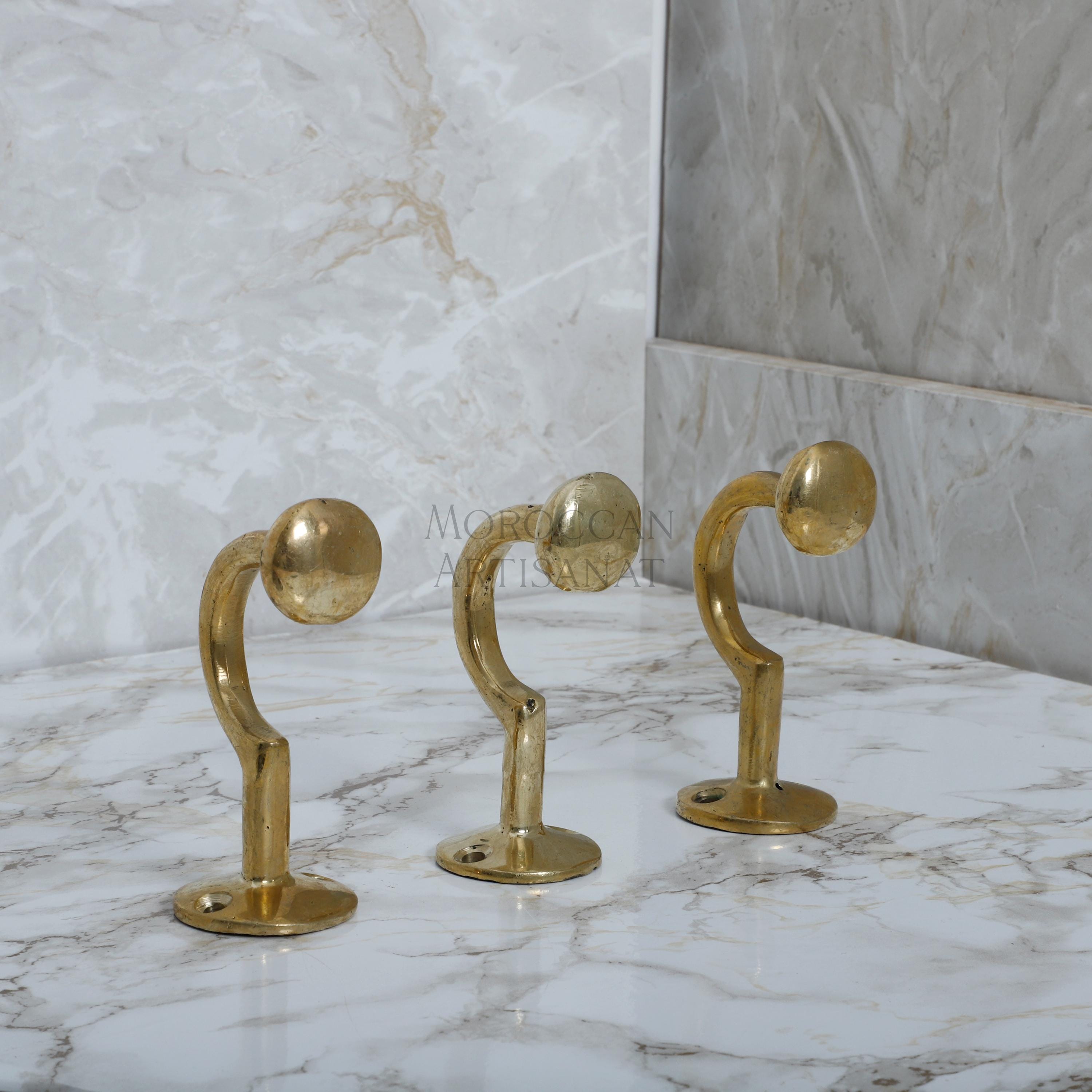 a marble counter top with three brass handles