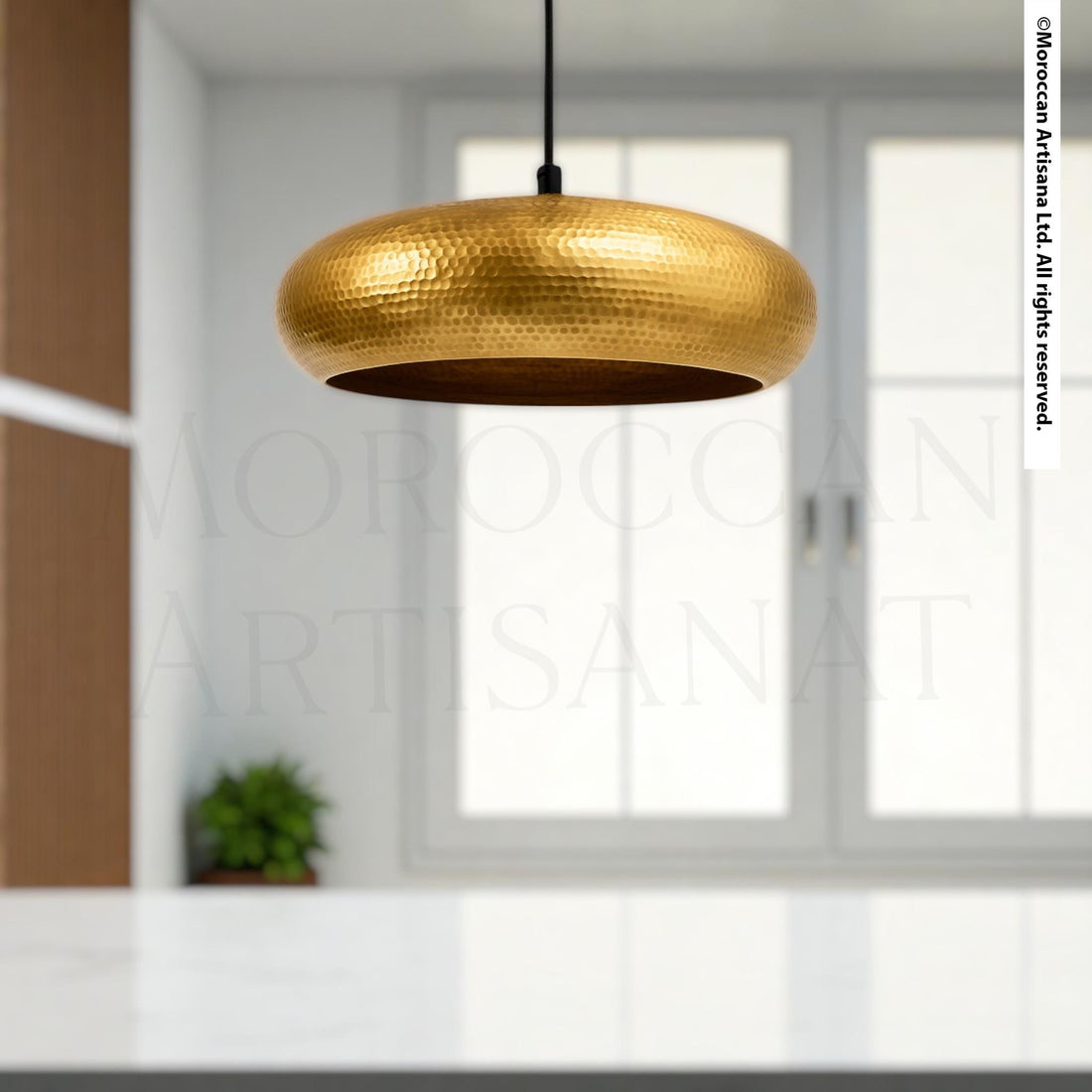 a modern, minimalist interior design with a large, gold-colored pendant light hanging from the ceiling.