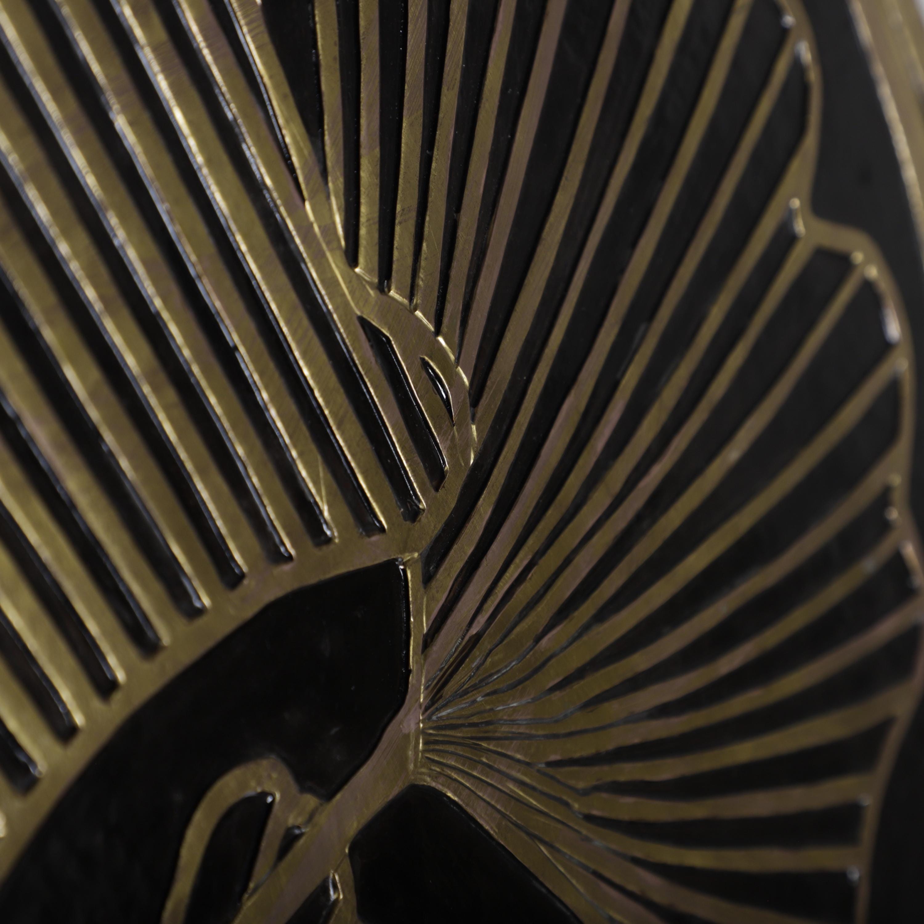 a close-up view of a black and gold metallic surface with a repeating pattern of thin, curved lines.
