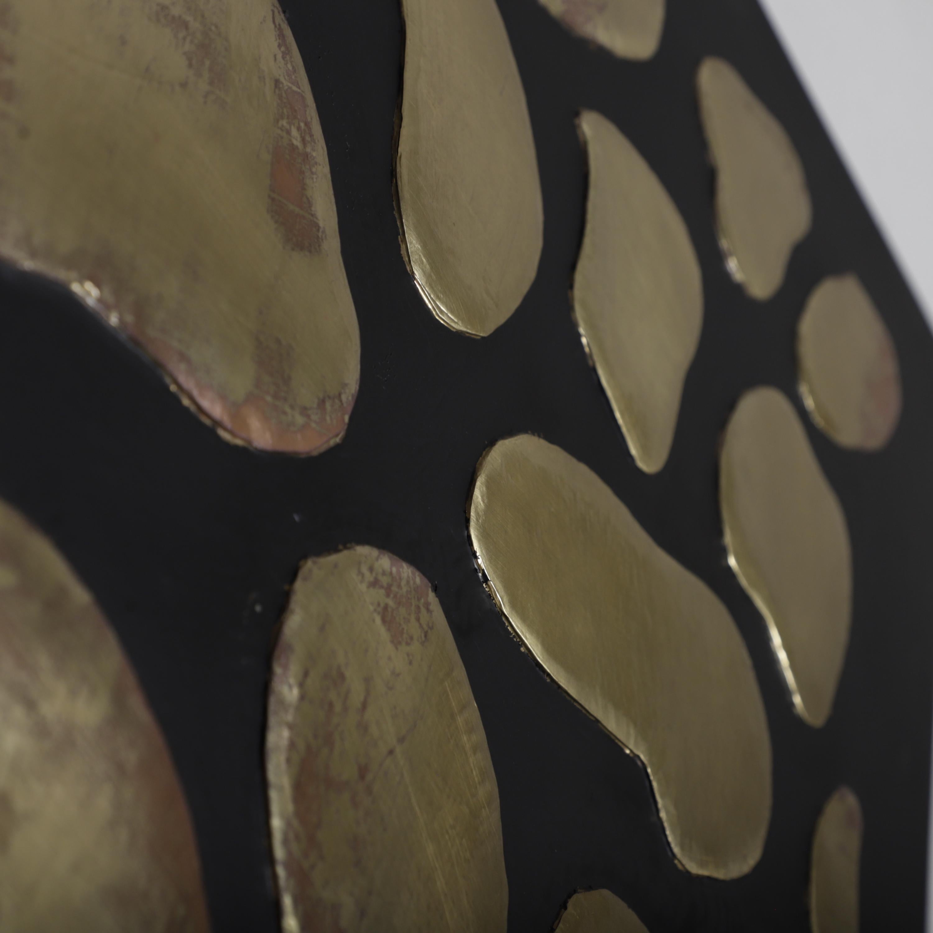 a close-up view of a black background with a pattern of gold-colored circles or ovals on it.