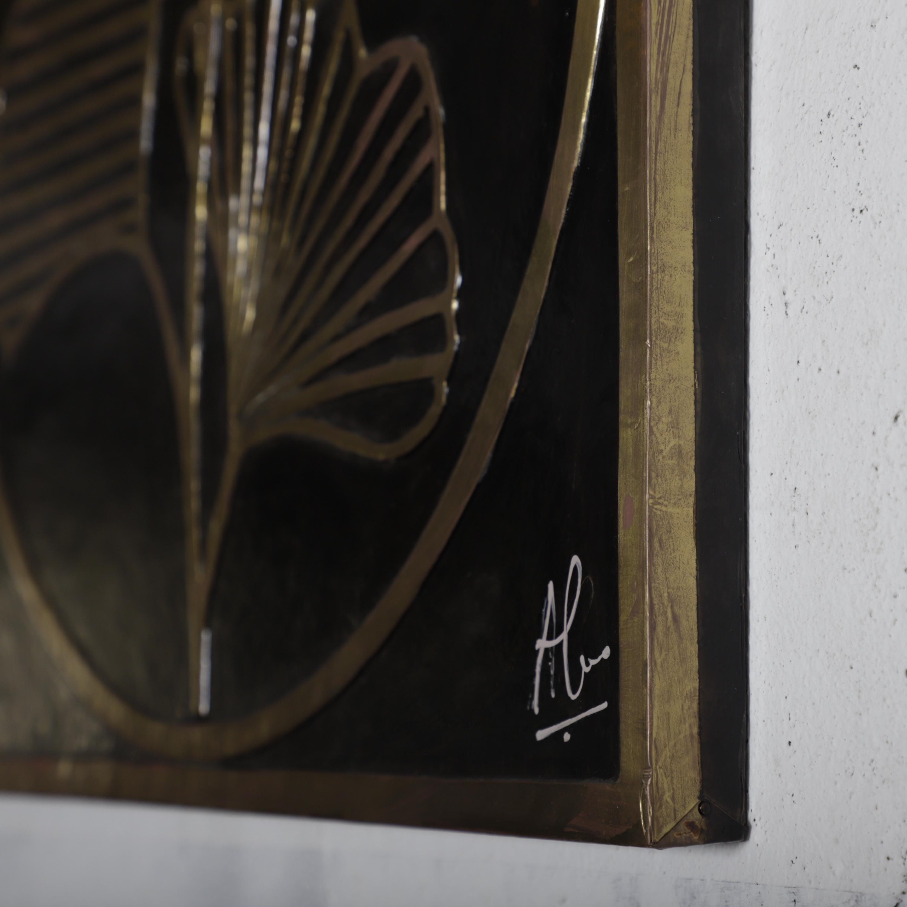 a close-up view of a framed artwork with a gold frame and a black background. The artwork appears to be a painting or drawing, with a signature in the bottom right corner.