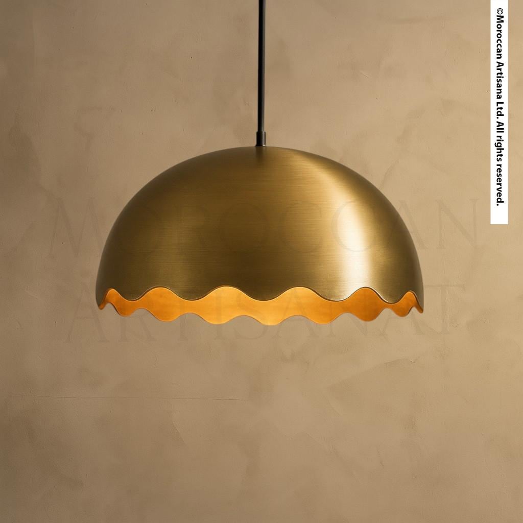 A gold-colored pendant light with a scalloped edge is suspended from the ceiling.