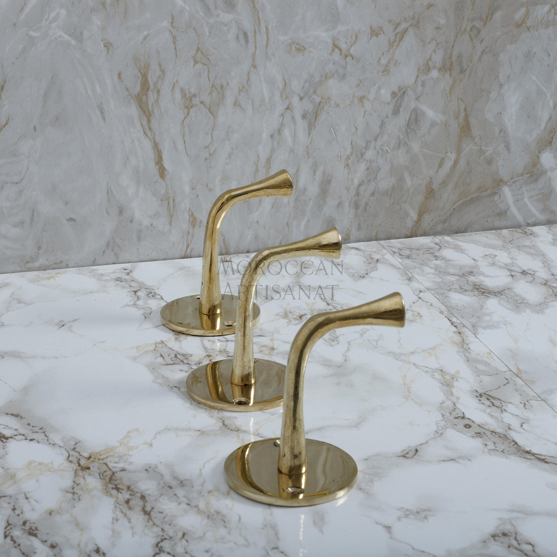 a marble counter top with three brass handles