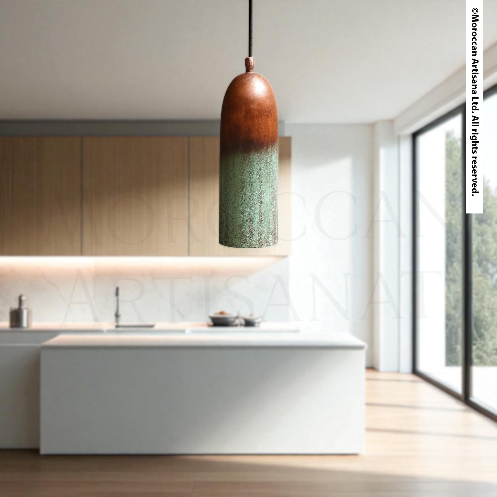 A modern kitchen with a large window, white countertops, and a hanging pendant light with a green and brown color scheme.