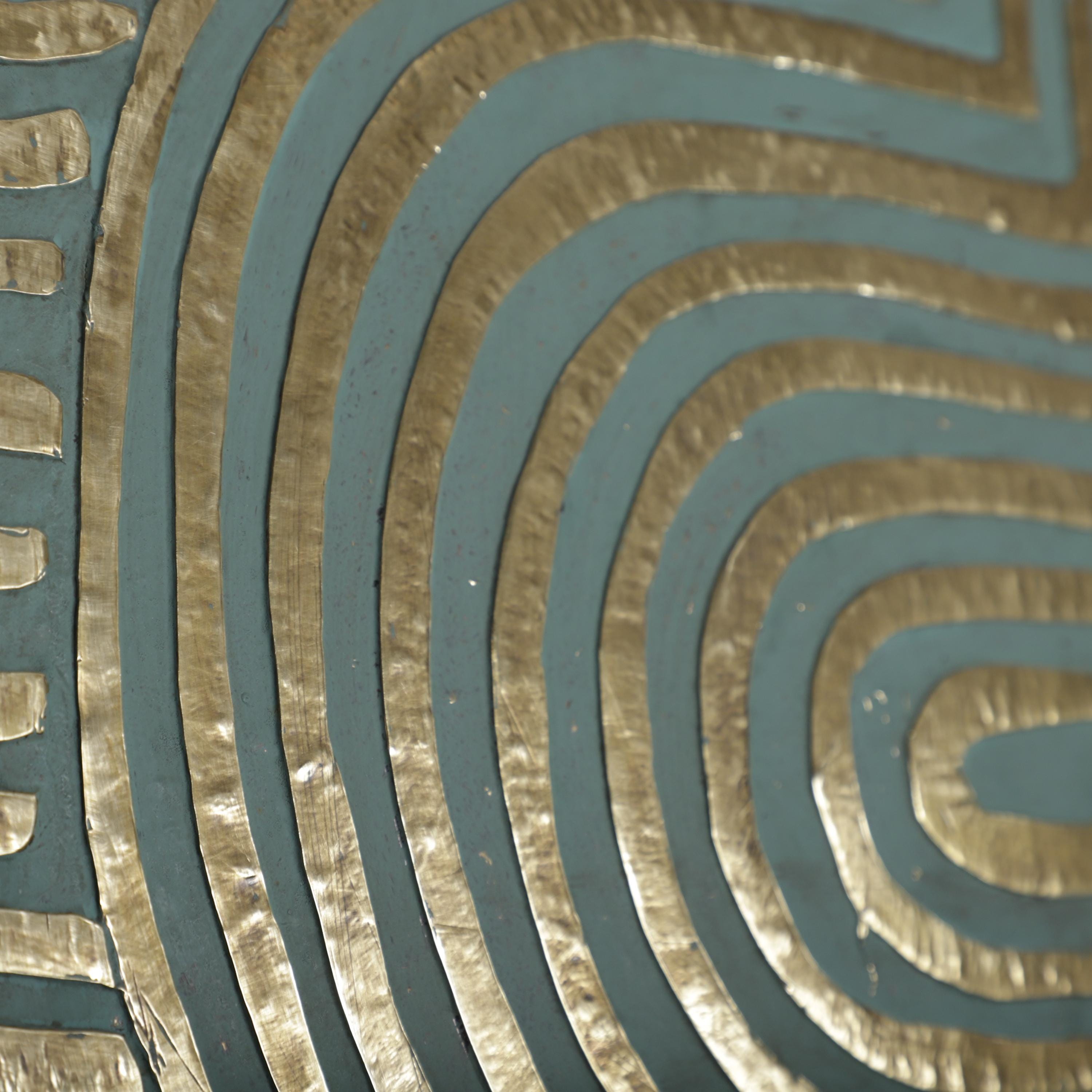 a close-up view of a blue and gold patterned surface, with a repeating design of curved lines and metallic elements.