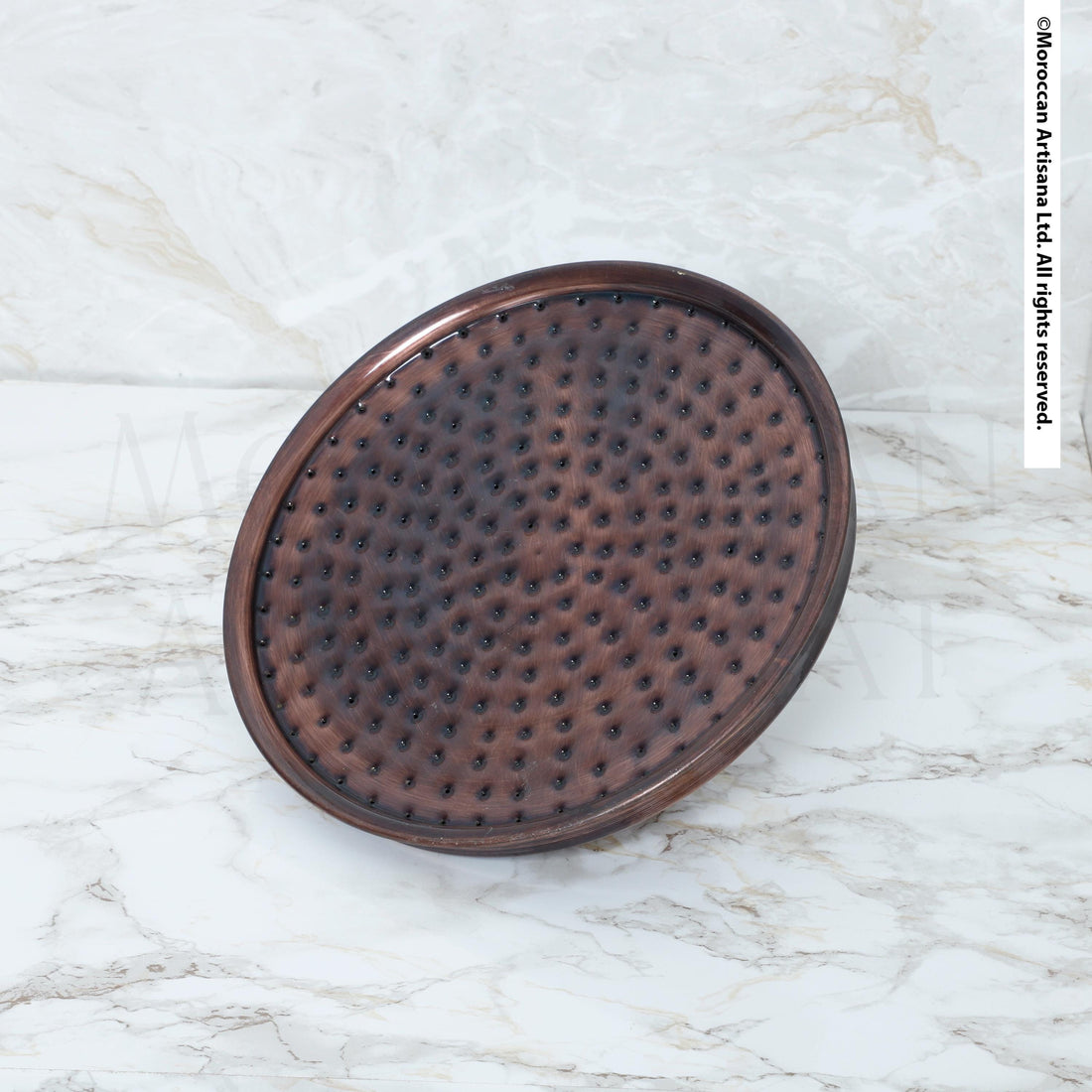 a round, brown, textured object placed on a white marble surface.