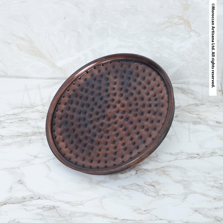 a round, brown, textured object placed on a white marble surface.