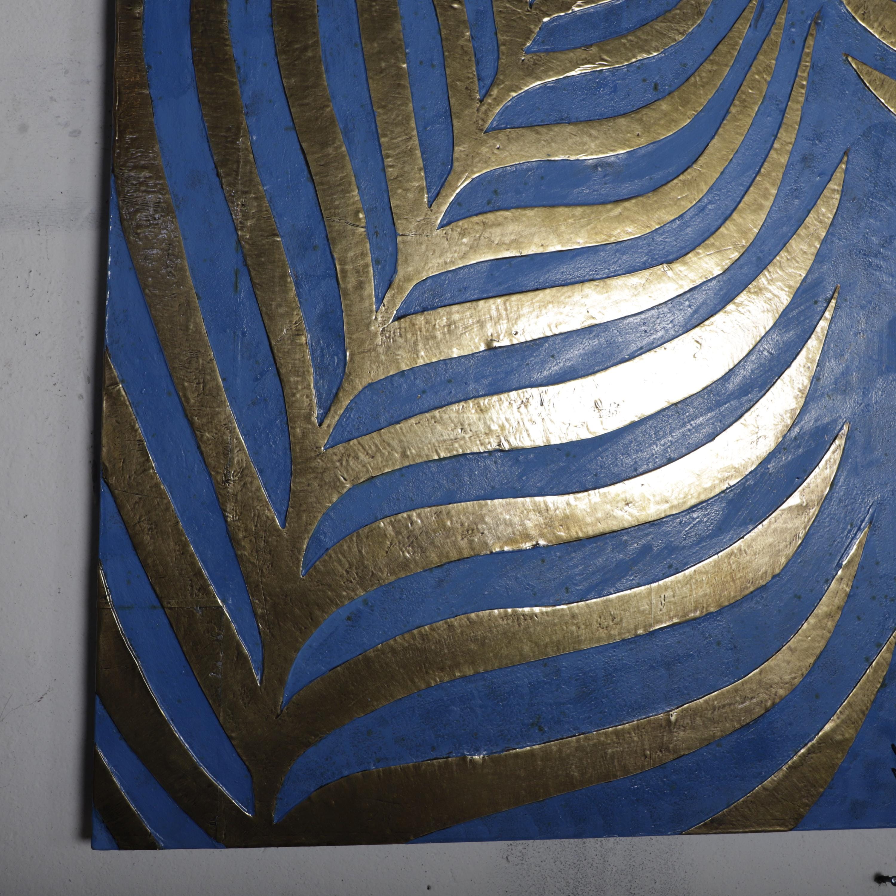 a close-up view of a blue and gold leaf-like pattern on a surface, with the pattern composed of overlapping curved lines in shades of blue and gold.