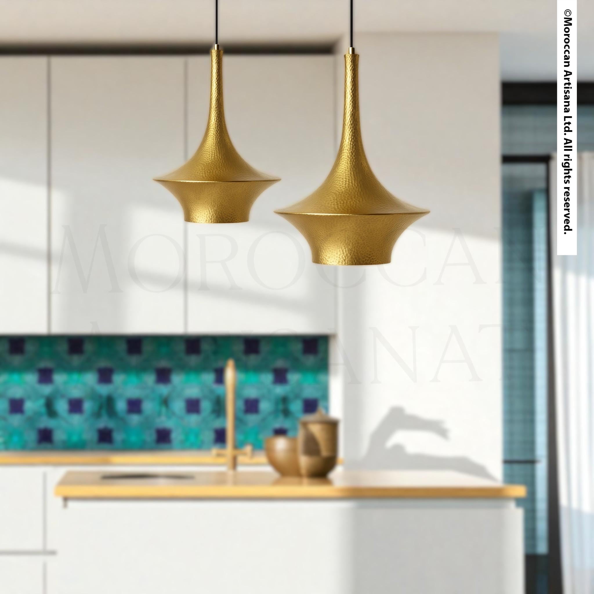 a modern kitchen with white cabinets and gold pendant lights hanging above the countertop.
