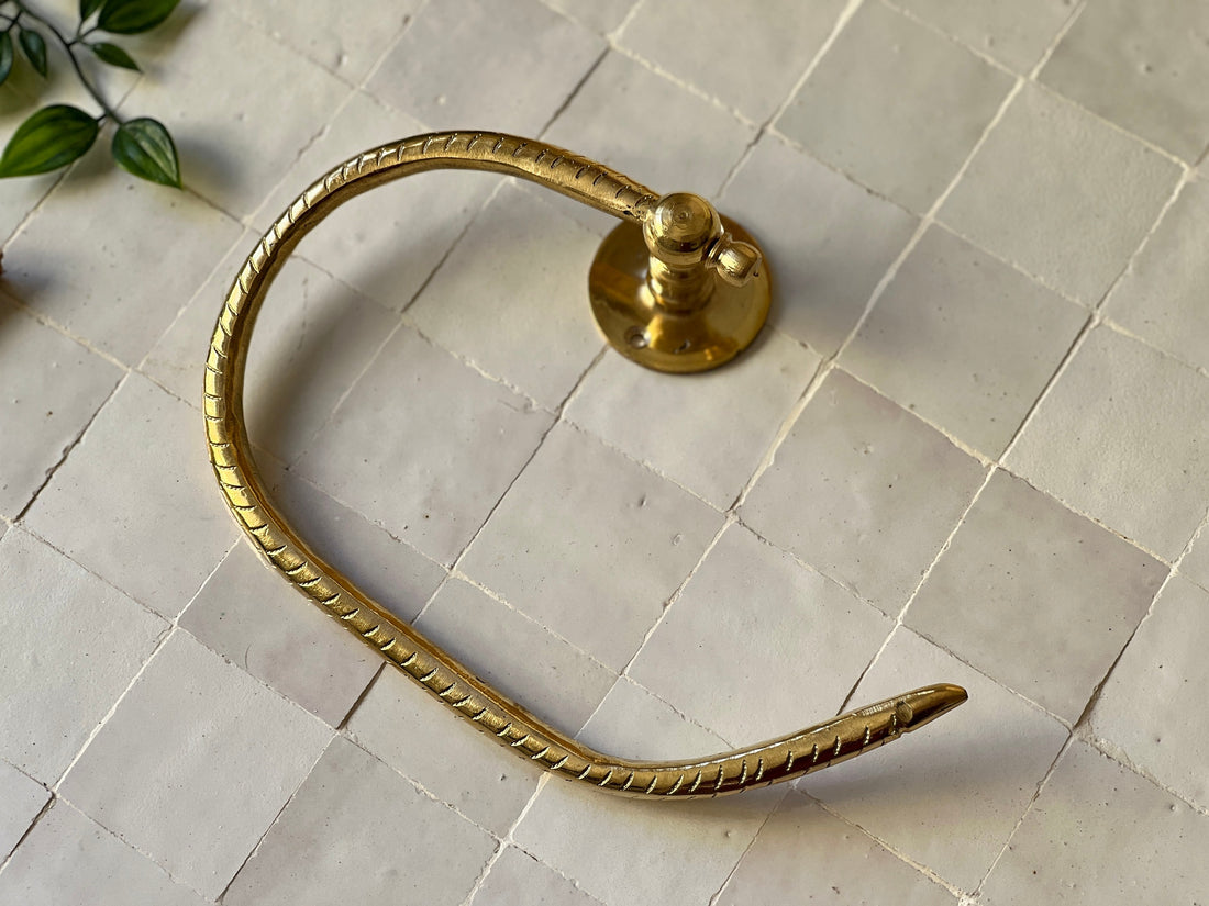 Elegant brass toilet paper holder with open-ended design for modern bathroom decor