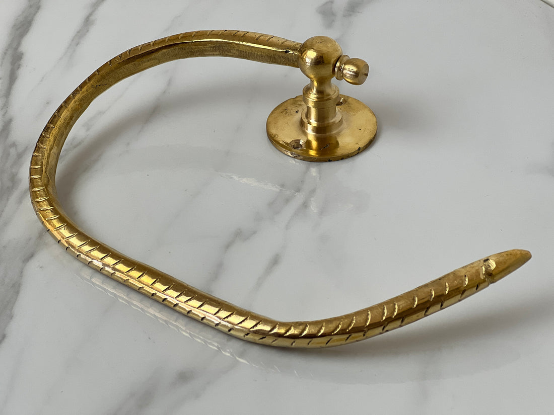 Elegant brass toilet paper holder with open-ended design for modern bathroom decor