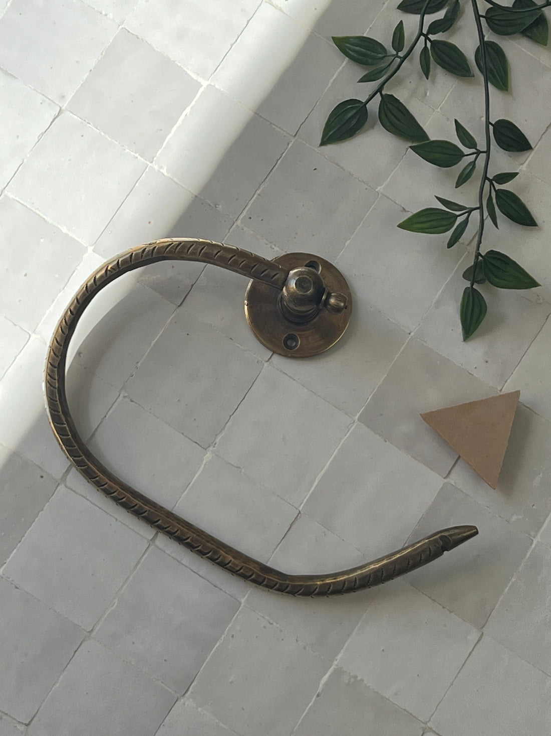 Elegant brass toilet paper holder with open-ended design for modern bathroom decor