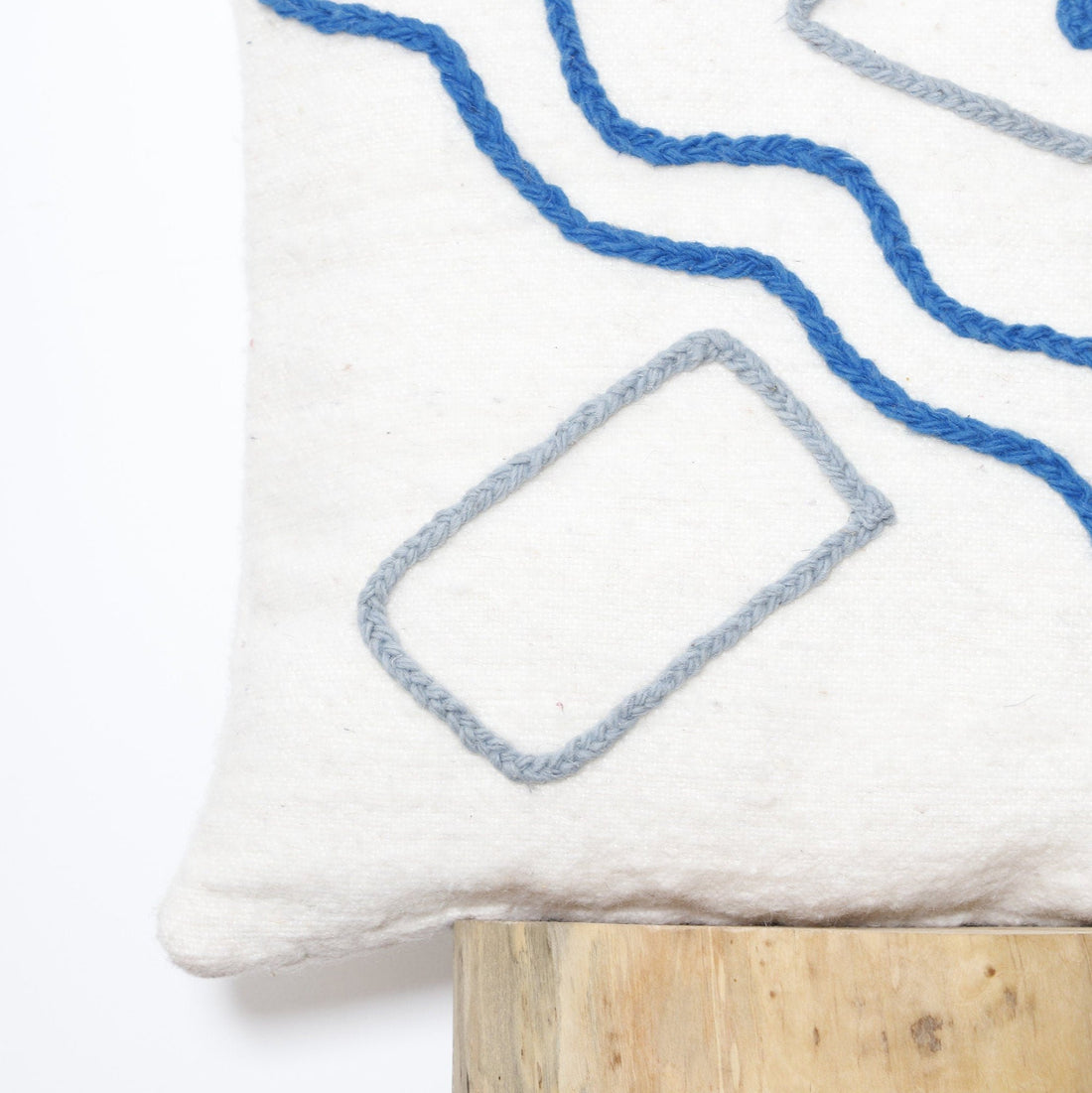 Artisan-made Moroccan pillow cover with handwoven wool, featuring neutral tones and colorful abstract designs.

