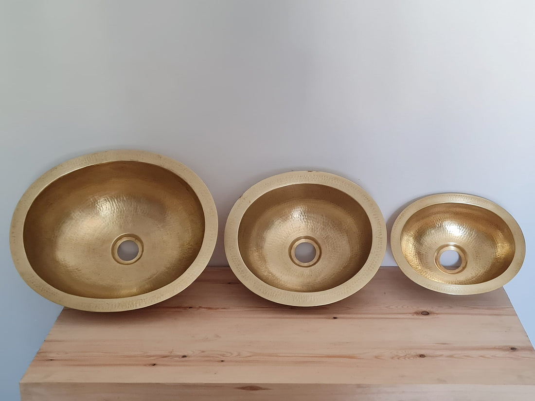 Elegant oval brass sink with a natural finish for a luxurious bathroom decor