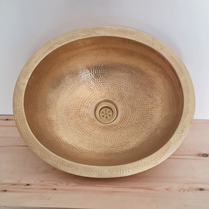 Elegant oval brass sink with a natural finish for a luxurious bathroom decor