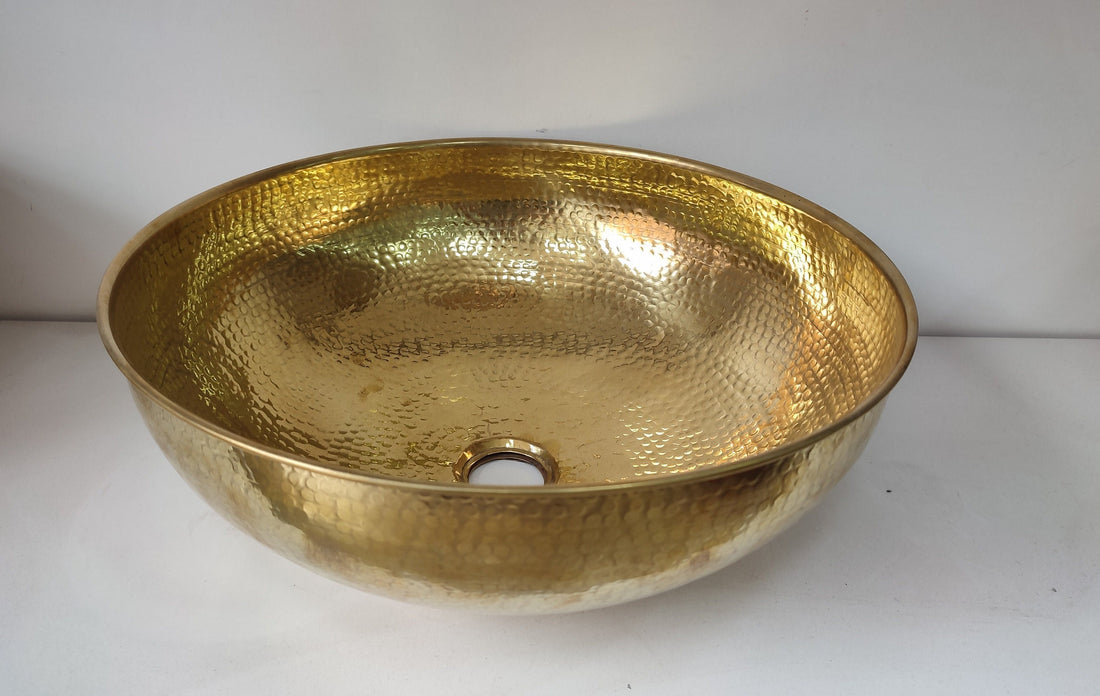 Round brass bathroom sink with a warm finish for an elegant bathroom design