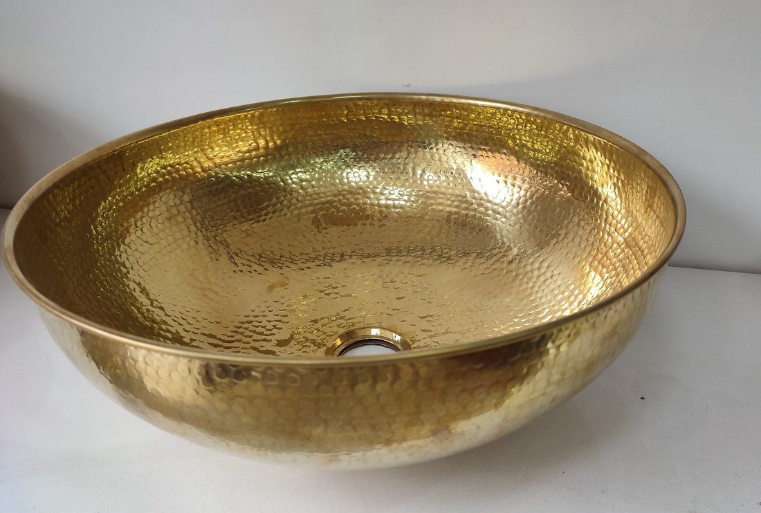 Round brass bathroom sink with a warm finish for an elegant bathroom design