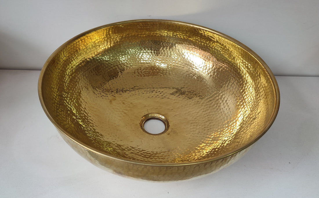 Round brass bathroom sink with a warm finish for an elegant bathroom design