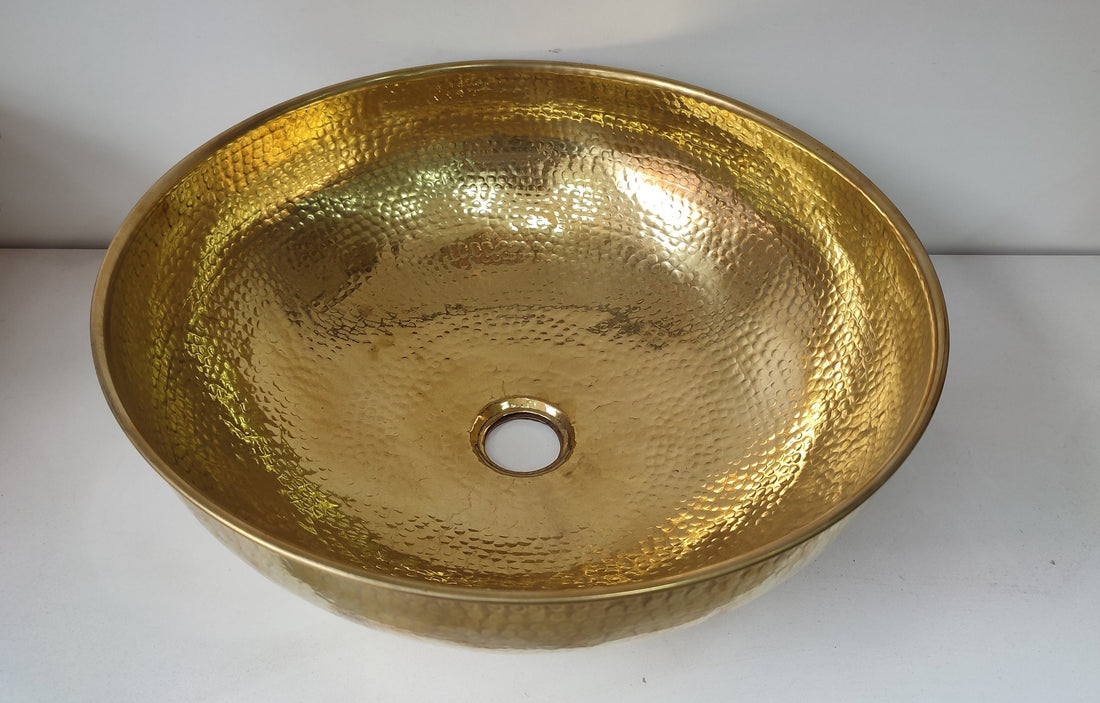 Round brass bathroom sink with a warm finish for an elegant bathroom design