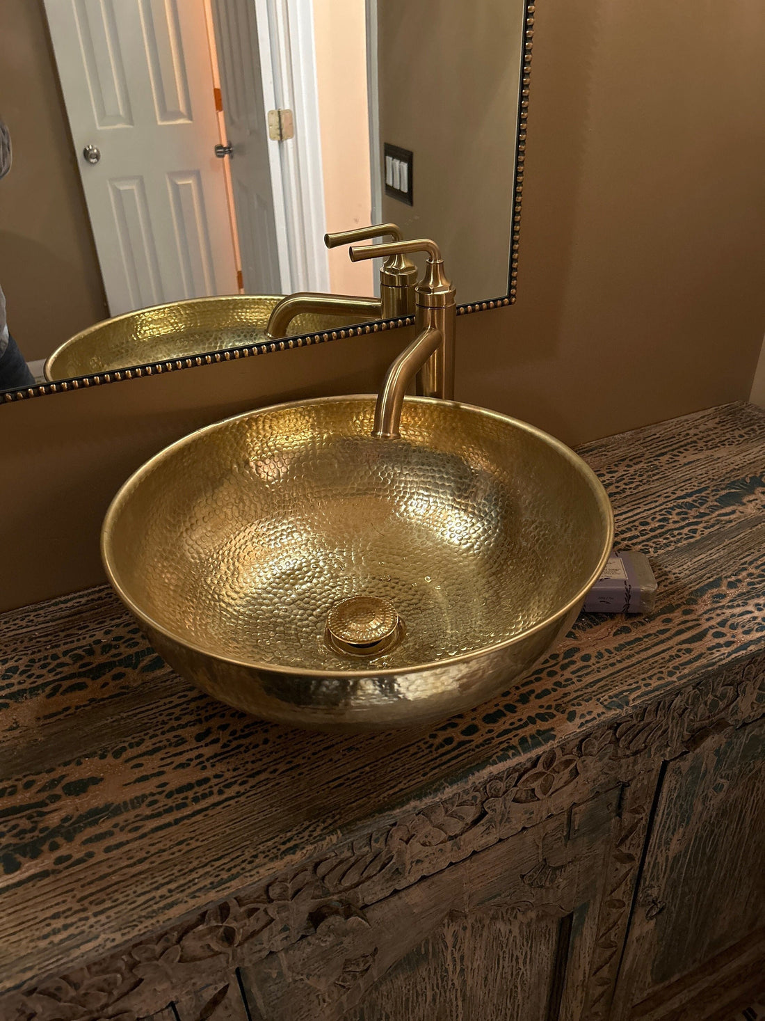 Round brass bathroom sink with a warm finish for an elegant bathroom design