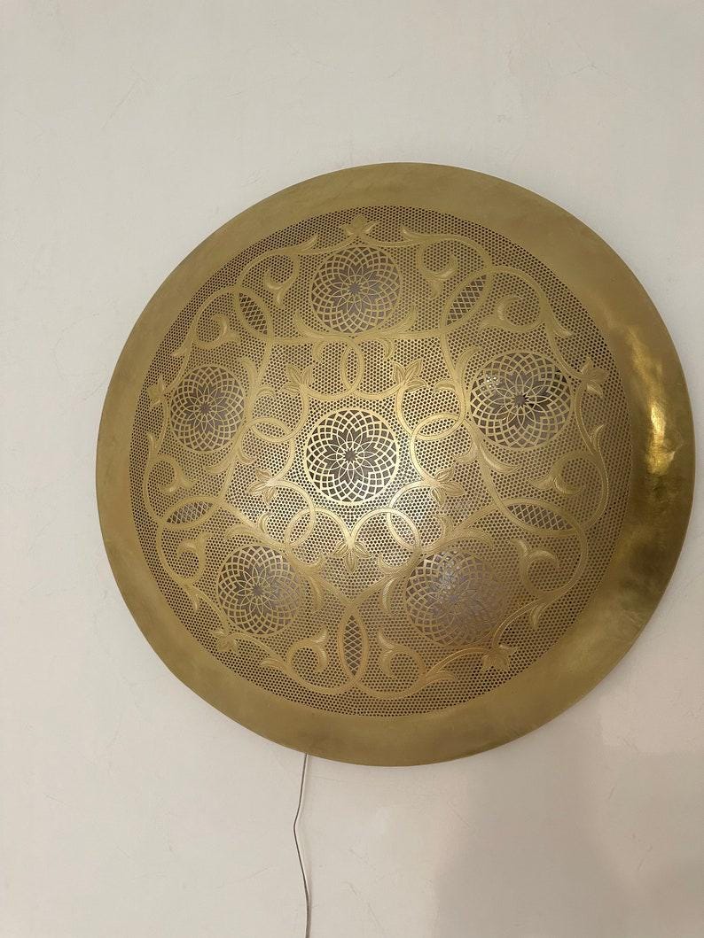 Handmade brass round wall light with sleek design for elegant and timeless lighting decor