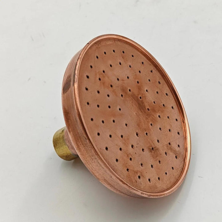 Copper rainfall shower head with a wide spray design for a luxurious spa-like experience