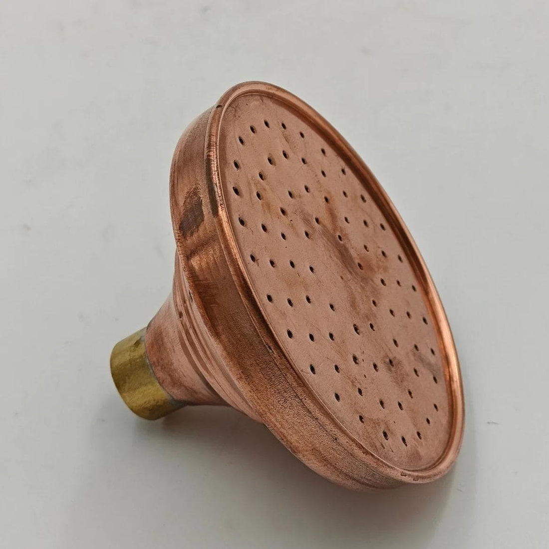 Copper rainfall shower head with a wide spray design for a luxurious spa-like experience