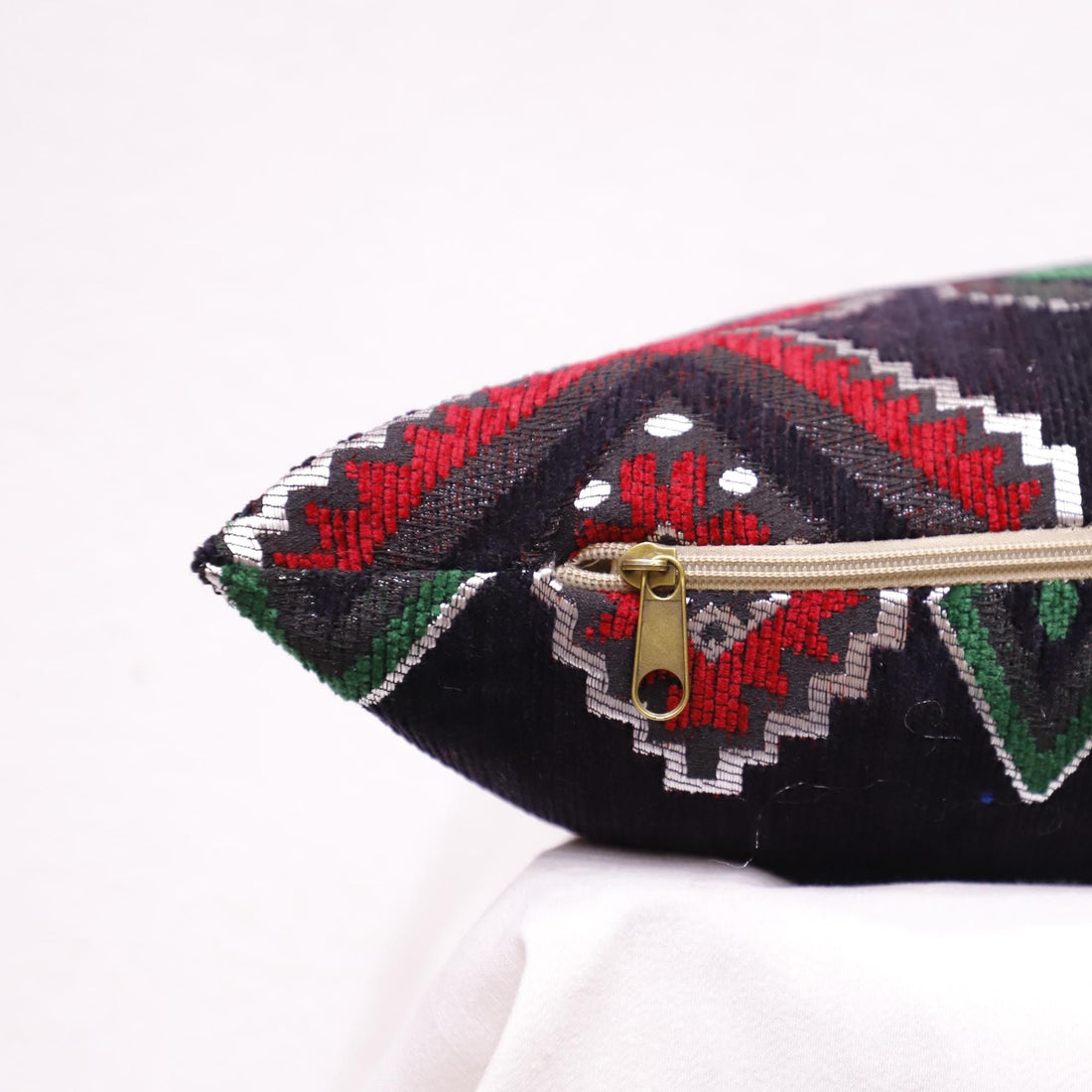 Ethnic Moroccan pillow case with traditional patterns on an accent chair.