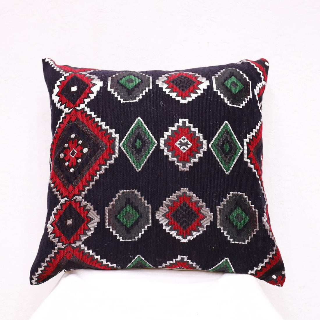 Ethnic Moroccan pillow case with traditional patterns on an accent chair.