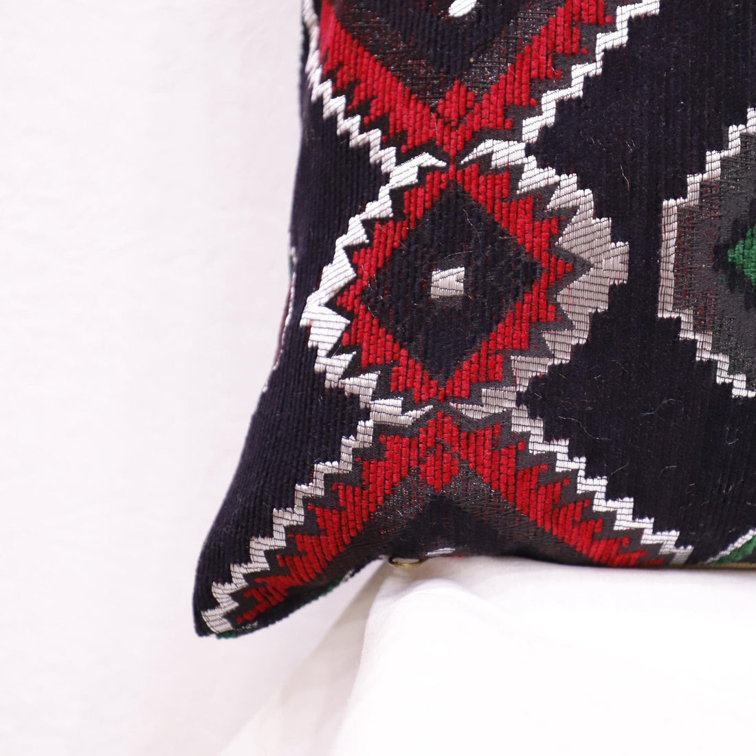 Ethnic Moroccan pillow case with traditional patterns on an accent chair.