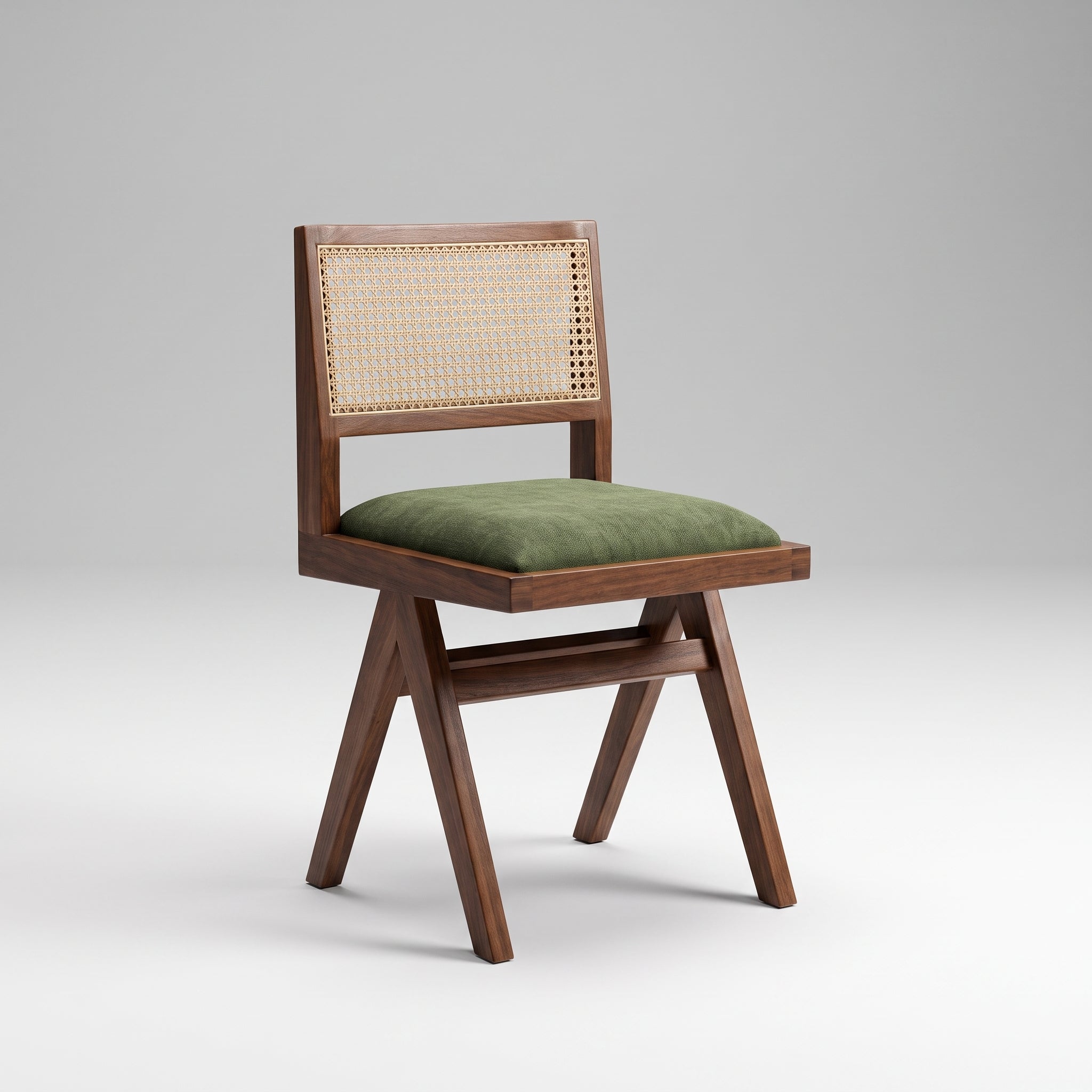 A mid-century modern wooden dining chair with a woven cane backrest and an olive green velvet seat cushion, shown on a light gray studio background.